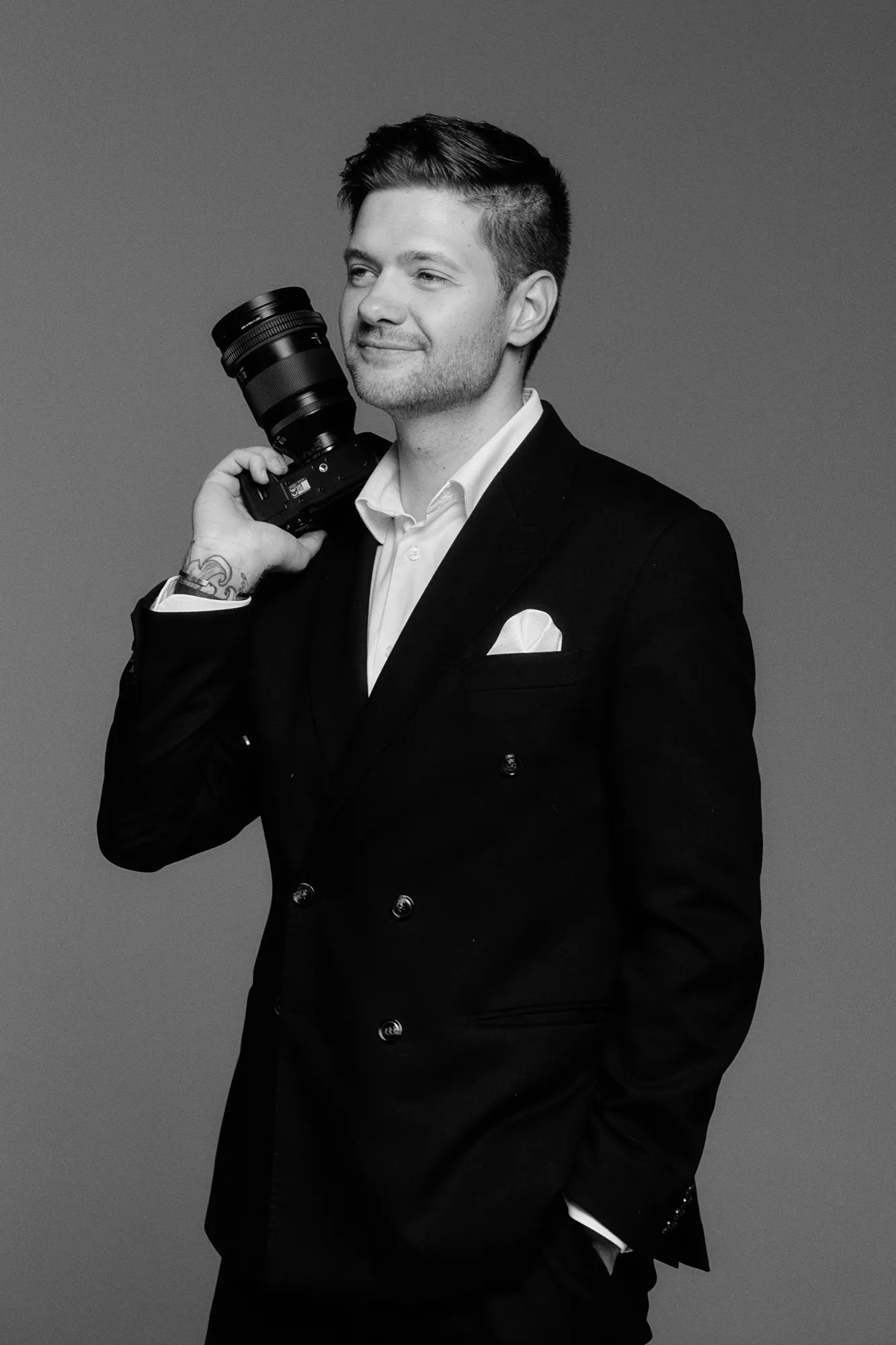 Julian Müller mit seiner Kamera, Hochzeitsfotograf aus Düsseldorf, Schwarzweiß-Porträt