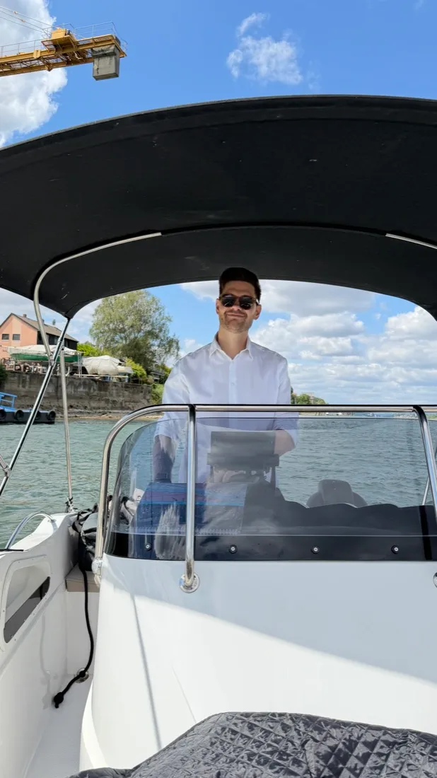 Julian am Steuer eines Bootes auf dem Rhein