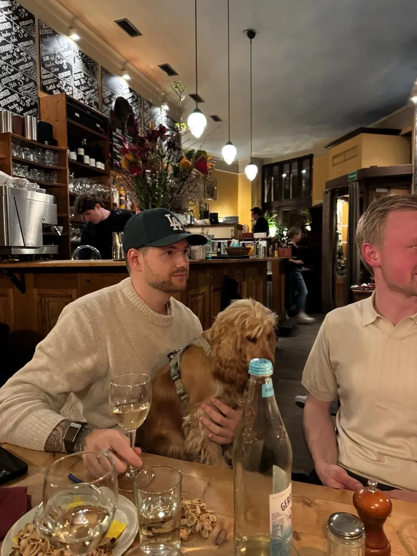 Julian in einer Kneipe mit einem Hund auf dem Schoß