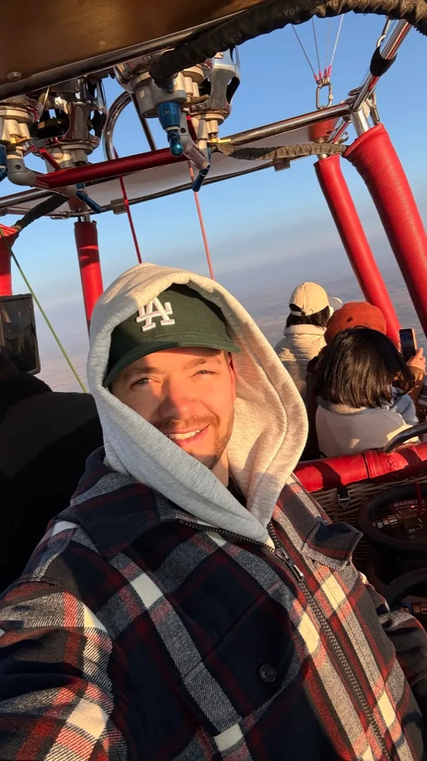 Julian im Korb eines Heißluftballons bei Sonnenaufgang